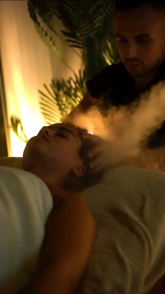 γυναίκα κάνει μασάζ κεφαλής και προσώπου με ατμο από θεραπευτή σπα