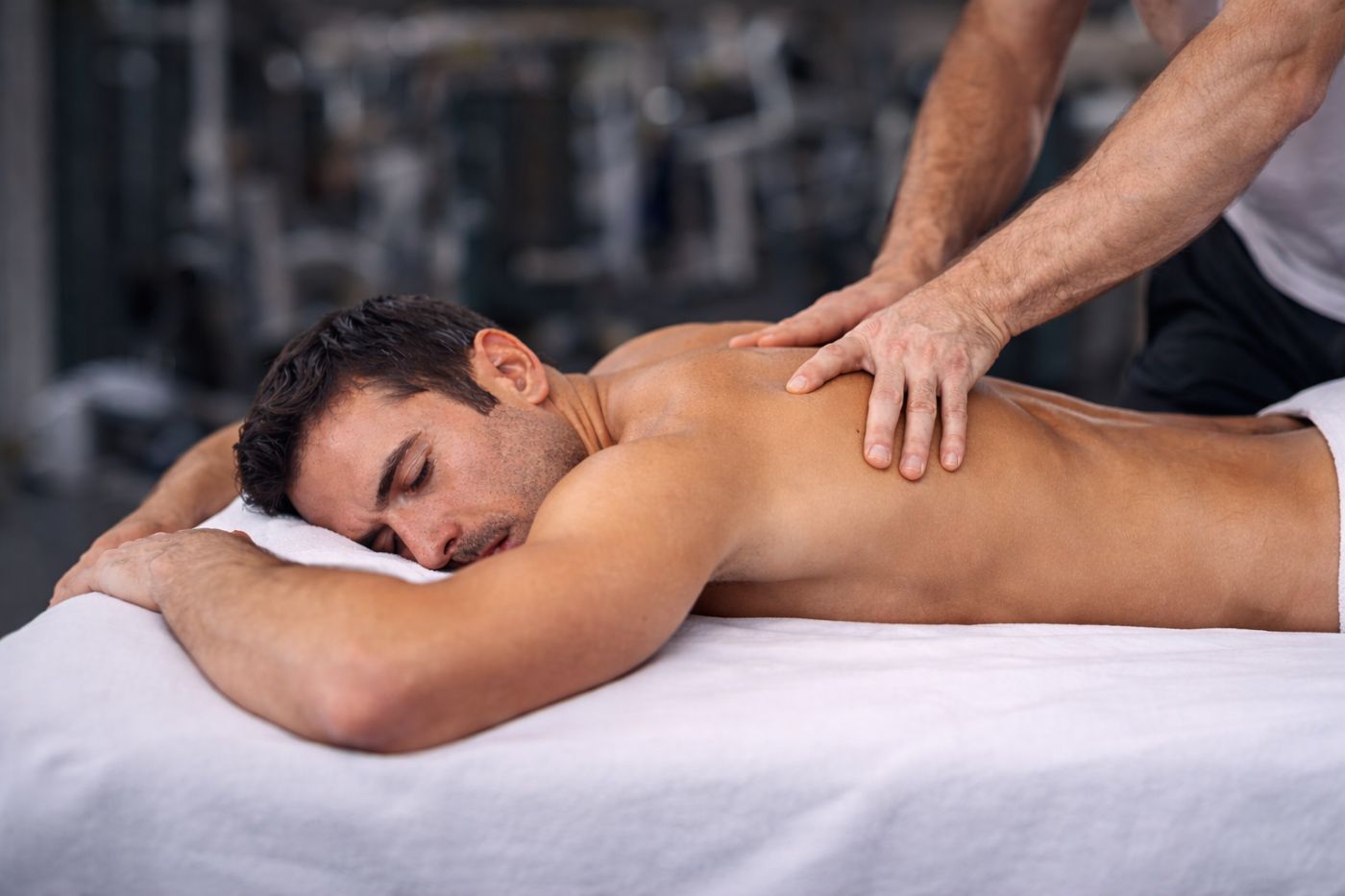 Αθλητικό μασάζ πλάτης σε άνδρα κατά τη διάρκεια συνεδρίας αποκατάστασης
